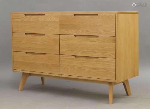 A contemporary oak chest of drawers, with six drawers on spl...