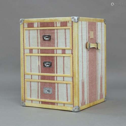 A modern side chest in the form of a travel trunk, with pink...