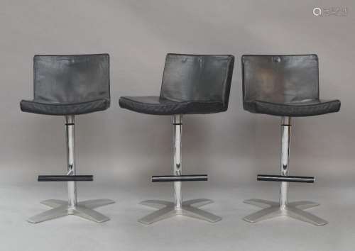 A set of three modern swivel stools, with black leather upho...