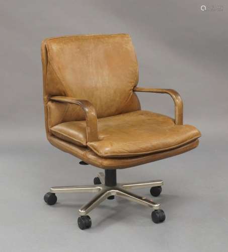 A modern tan leather swivel desk chair, by Geiger BrickelA m...