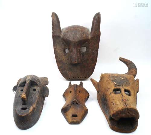 Four African masks, to include a mask with headdress, elonga...