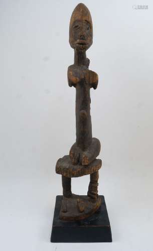 A Dogon maternity figure, Mali, depicting a mother sat on a ...