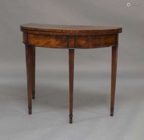 A George III mahogany bow front card table, raised on square...