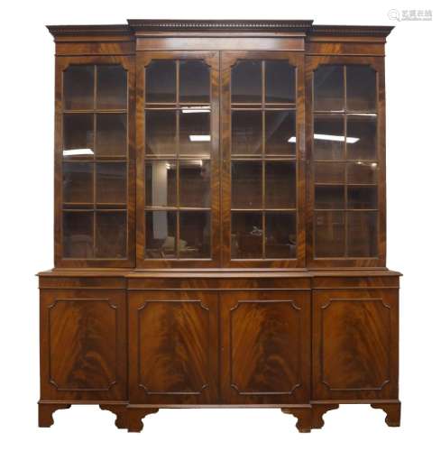 A George III style mahogany breakfront bookcase, with dentil...