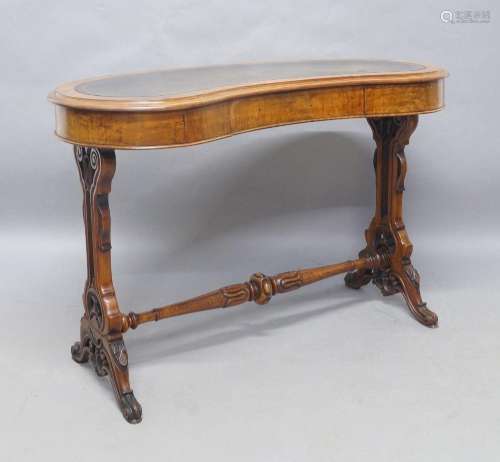 A Victorian walnut kidney shaped writing table, with leather...
