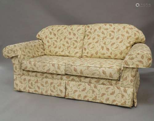 A modern hump back sofa, the beige upholstery with floral de...