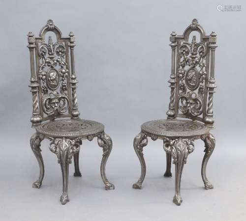 A pair of Victorian style cast iron chairs, the back rests w...