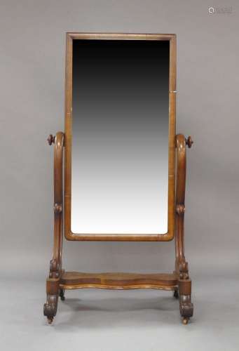 A Victorian mahogany cheval mirror, raised on scrolling feet...