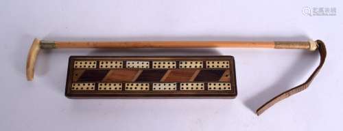 AN ANTIQUE BONE AND MIXED HARDWOOD CRIBBAGE BOARD with fist ...