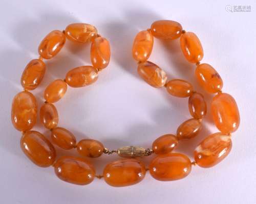 AN AMBER TYPE NECKLACE WITH GRADUATED BEADS. Length 73cm, we...