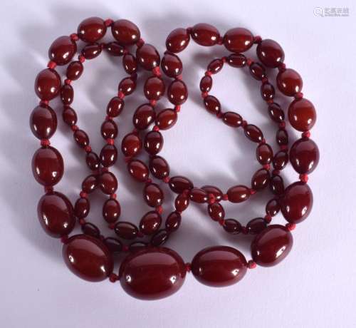 A GRADUATED CHERRY AMBER COLOURED BEAD NECKLACE. Length 96cm...
