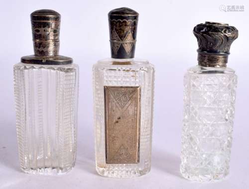 THREE SILVER TOPPED SCENT BOTTLES. Largest 9cm x 3.3cm x 2.3...