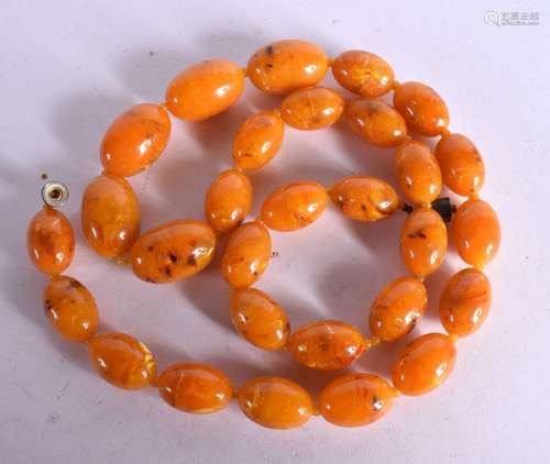 AN AMBER COLOURED BAKELITE NECKLACE. Length 85cm, bead size ...