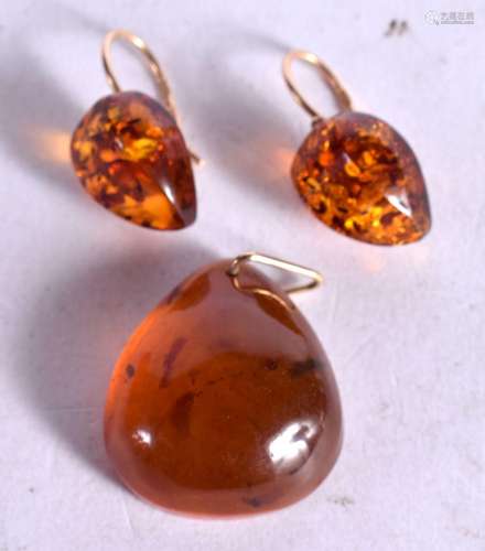 A GOLD MOUNTED AMBER PENDANT WITH MATCHING EARRINGS. Stamped...