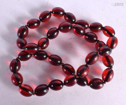 A STRING OF CHERRY COLOURED BEADS. 62cm long, weight 65g