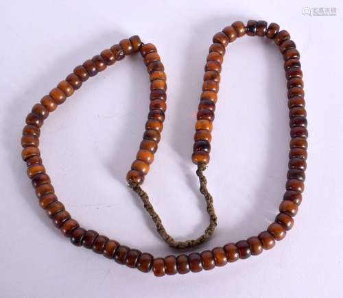 A MIDDLE EASTERN CARVED AMBER TYPE PRAYER BEAD NECKLACE. 87 ...