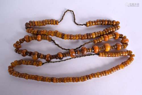 THREE LARGE MIDDLE EASTERN CARVED AMBER TYPE PRAYER NECKLACE...