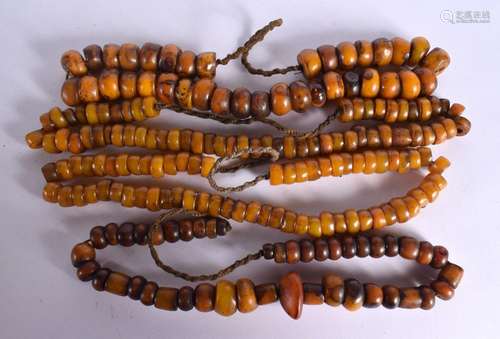 FOUR LARGE MIDDLE EASTERN CARVED AMBER TYPE PRAYER NECKLACES...