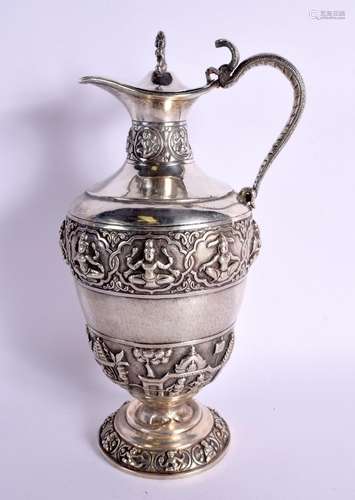 AN ANTIQUE INDIAN WHITE METAL EWER decorated with Buddhistic...