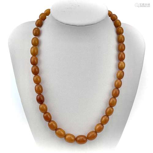 A butterscotch amber graduated oval bead necklace.