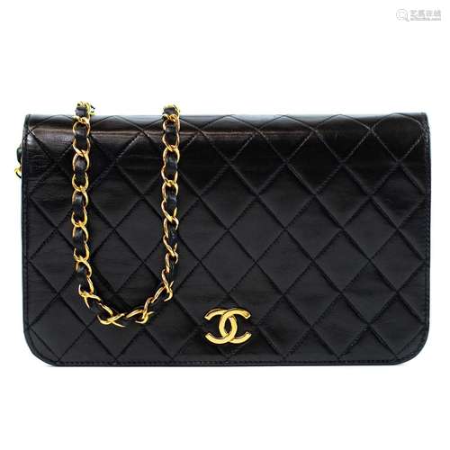 A Chanel wallet full flap handbag on chain in black quilted ...