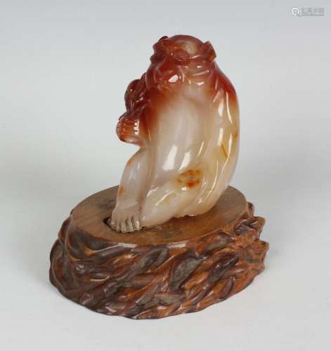 A Chinese carved agate figure of a seated monkey