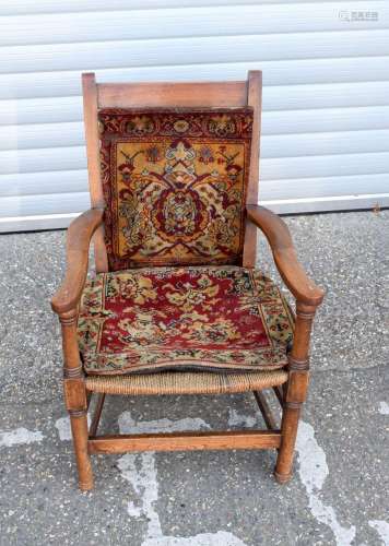 A antique oak arm chair with reed seat and later cushions 82...