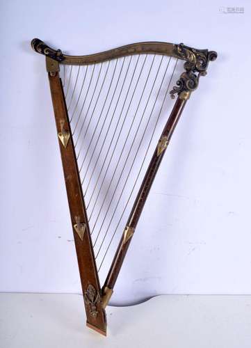 An unusual wooden and brass hat rack in the form of a harp. ...