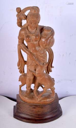 A carved wood figure of an Indian female on a wooden plinth....