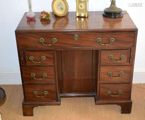 A GOOD GEORGE III KNEEHOLE DESK with one long and six small ...