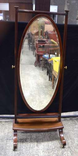 A large antique full length mahogany mirror with castors to ...