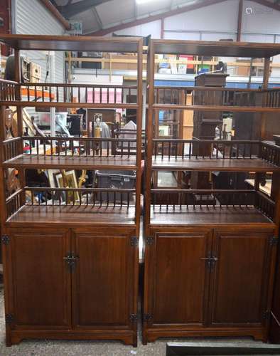 A large pair of Chinese carved hardwood cabinets with two ga...