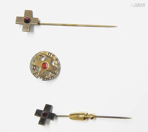 3 verschiedene Anstecknadeln mit stilisiertem Kreuz, eines d...