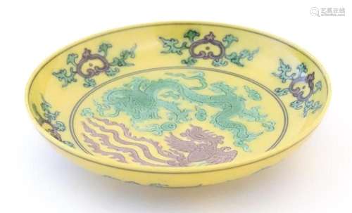 A small Chinese plate with a yellow ground with dragon and p...