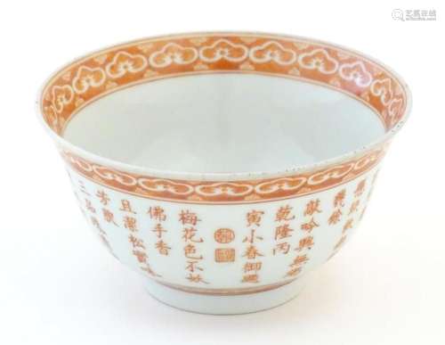A small Chinese red and white bowl decorated with flowers an...