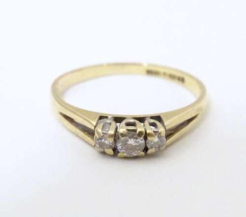 A 9ct gold ring set with trio of diamonds. Ring size approx ...