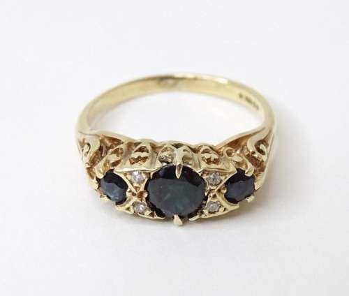 A 9ct gold ring set with sapphires and diamonds. Ring size a...