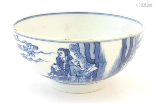 A Chinese blue and white bowl decorated with figures in a ga...