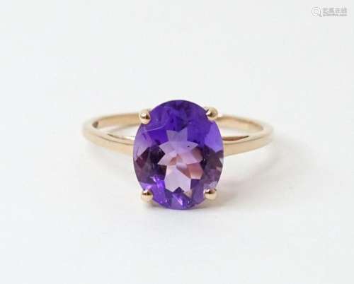 A 9ct gold ring set with central amethyst. Ring size approx....