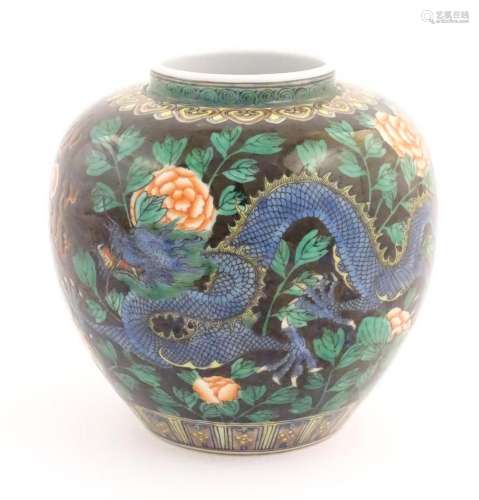 A Chinese famille noir vase decorated with two dragons and a...