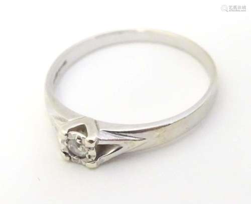 A 9ct white gold ring set with diamond solitaire. the ring a...