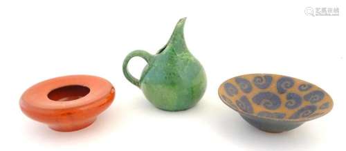 Three studio pottery items to include a green glazed jug wit...