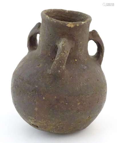 A pottery three handled vase with a bulbous body in the mann...
