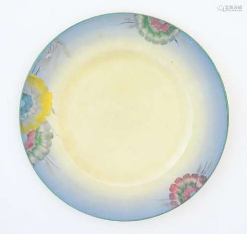 A Clarice Cliff plate decorated with a floral border. Marked...