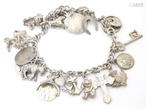 A silver / white metal charm bracelet set with various charm...