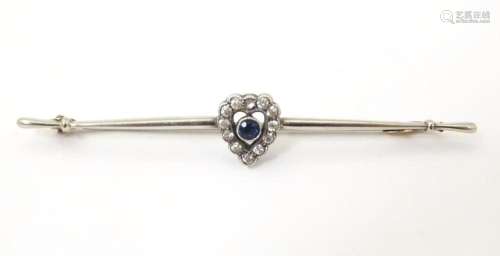 A 9ct white gold bar brooch set with blue stone bordered by ...