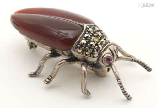 A silver and white metal brooch formed as a beetle, with red...