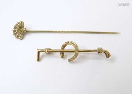 A yellow metal hunting stock pin formed as riding crop and h...