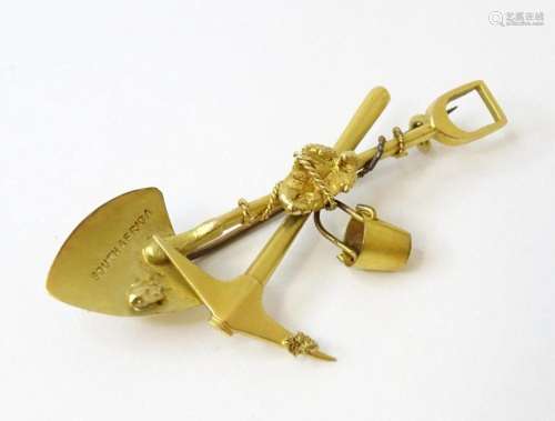 A 15ct gold brooch formed as a gold prospector s spade, axe ...