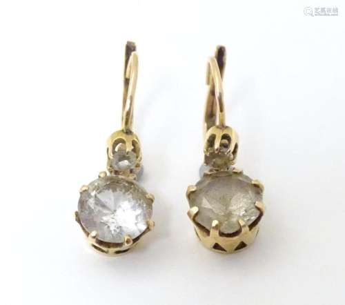 A pair of yellow metal drop earrings set with claw set white...